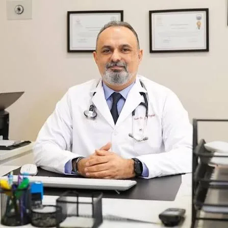 Uzm. Dr. Yunus Kayalar muayene odasında masasında oturuyor